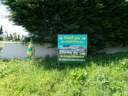 billboard in grass next to flag