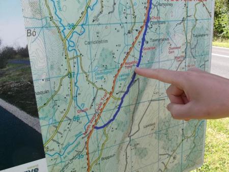finger pointing at megalithic tomb on map