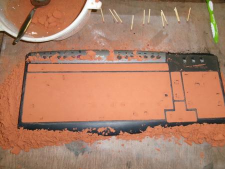 Orange oily sand pressed into computer keyboard