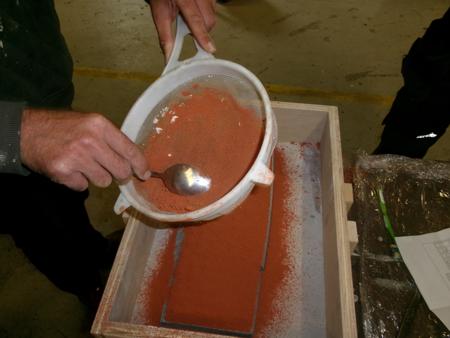 sifting orange sand over a keyboard