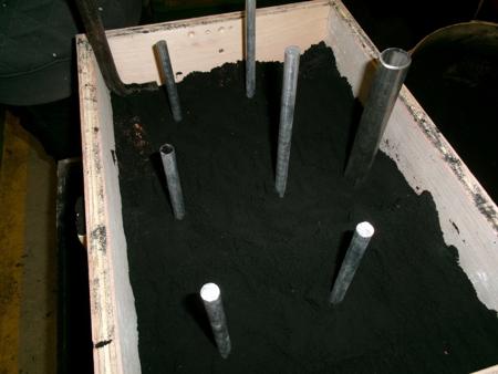 rods and a pipe placed into sand