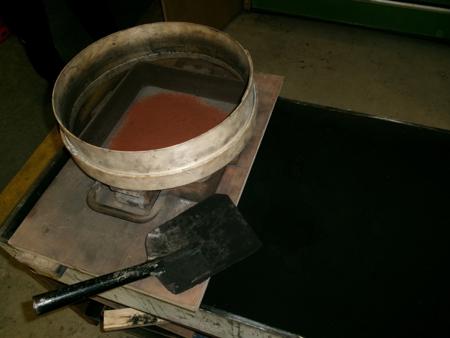 sifting black sand over orange sand