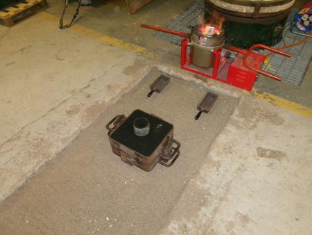 a mold on sand in front of a crucible